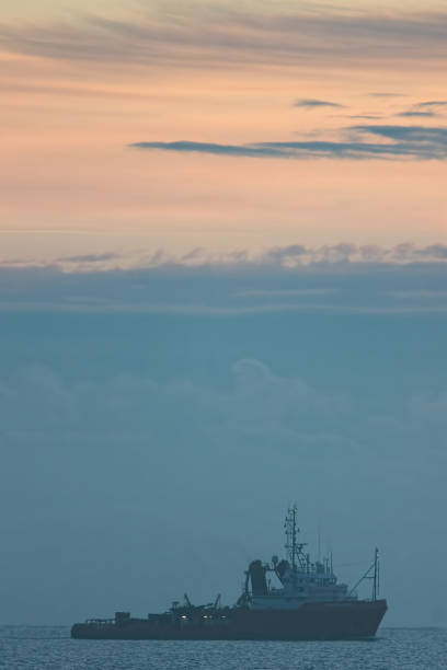 istock Soft focus painterly image of a boat at dawn in front of a beautiful cloudscape. Ship on a misty morning at sunrise. 854602282