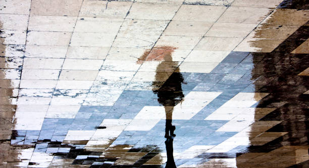 istock Reflection silhouette of one woman with umbrella 854607422
