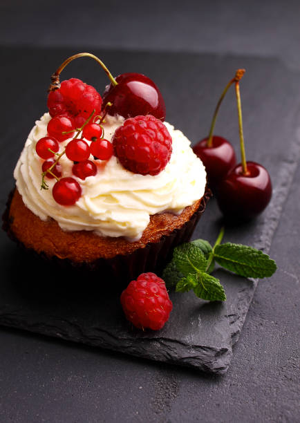 istock homemade cupcake with a cream, decorated with mint and berries 854609030