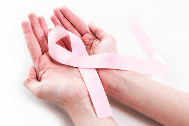 Closeup Old woman hand holding pink ribbon on white background ,Awareness breast cancer concept Closeup Old woman hand holding pink ribbon on white background ,Awareness breast cancer concept brest brittany photos stock pictures, royalty-free photos & images