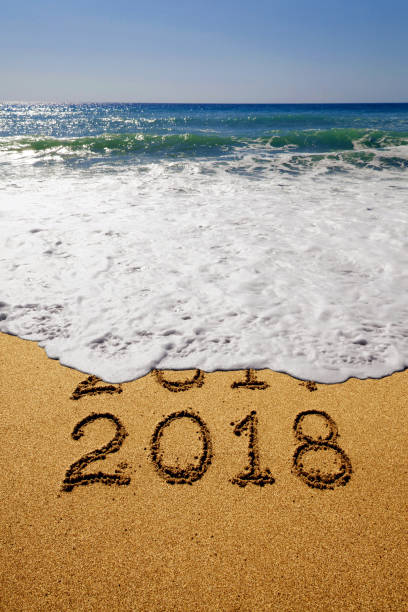 istock New year 2018 and 2017 on sandy beach with waves 854625706