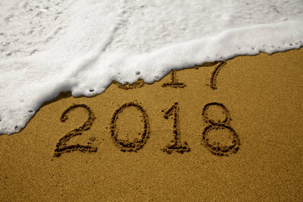 istock New year 2018 and 2017 on sandy beach with waves 854631836