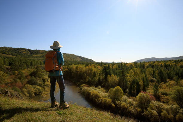 istock woman hiking with backpack at the riverside mountain 854635172
