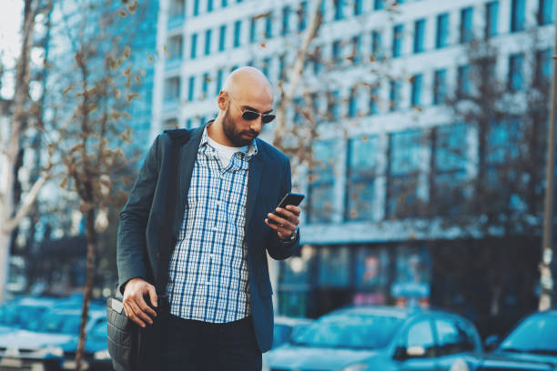 istock Businessman texting on the phone on street 854642170
