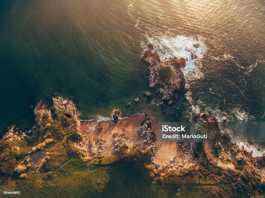 Aerial view of small rocky beach An aerial view of a small rocky beach at sunset Sea Stock Photo