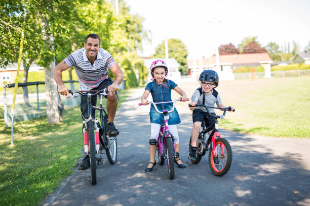 istock Dad With Daughter Son Riding Bikes In Park 854653594