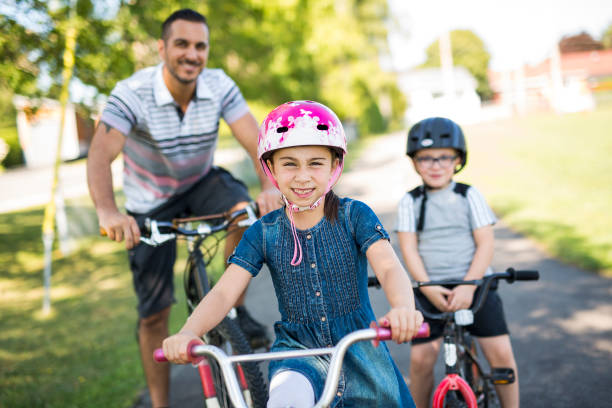 istock Dad With Daughter Son Riding Bikes In Park 854653730