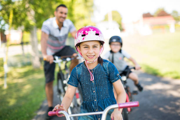 istock Dad With Daughter Son Riding Bikes In Park 854653780