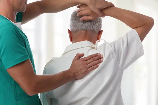 Photo of Senior man having chiropractic back adjustment. Osteopathy, Physiotherapy, pain relief concept