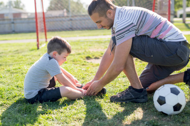 istock man with child playing football on field 854664206