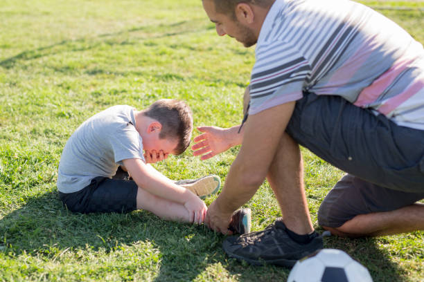 istock man with child playing football on field 854664272
