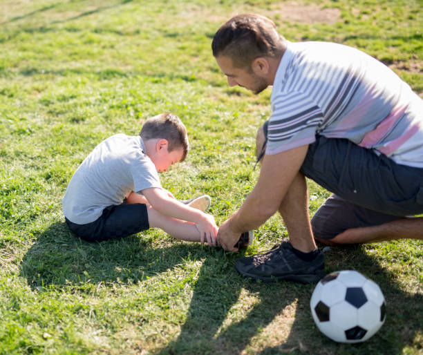 man with child playing football on field