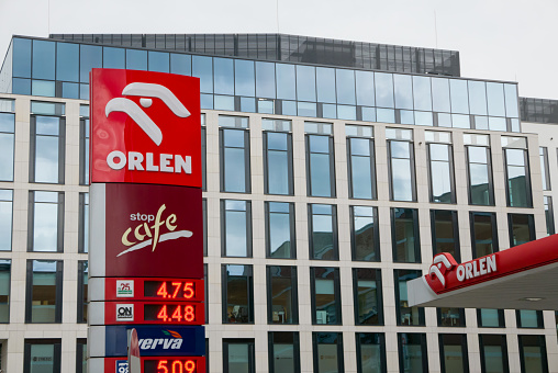 Wroclaw: Orlen logo on gas station with petrol prices displayed on electronic board with office building in the bacground. Orlen is the biggest petrol supplier in Central Europe