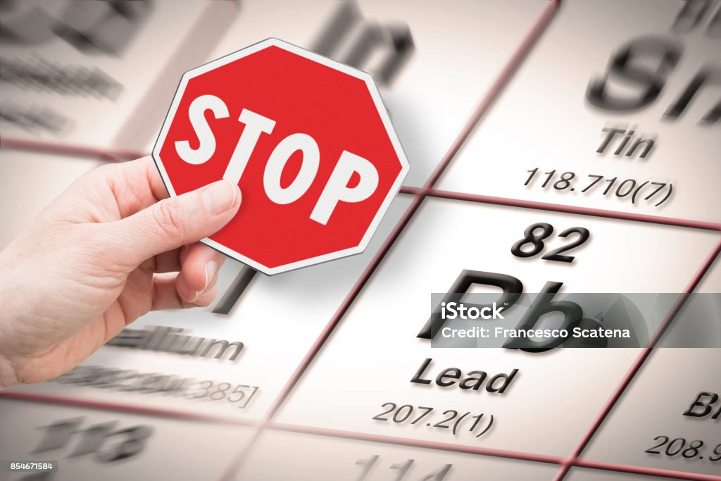 Stop heavy metals - Concept image with hand holding a stop sign against a Lead chemical element with the Mendeleev periodic table on background Lead Stock Photo