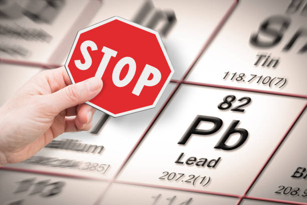 stop heavy metals - concept image with hand holding a stop sign against a lead chemical element with the mendeleev periodic table on background - mendeleev table imagens e fotografias de stock