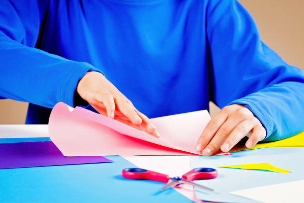 istock Kid folding colored paper and making origami. 854673750