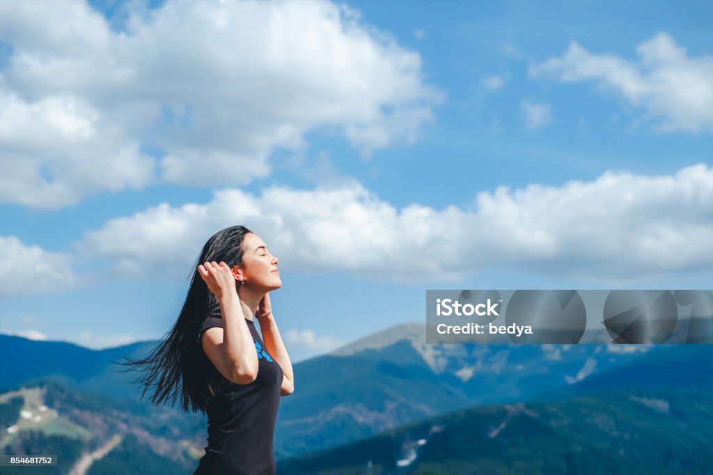 Tourist girl enjoy nature Long hair brunette girl on the top of the mountain enjoying fresh air Breath Vapor Stock Photo