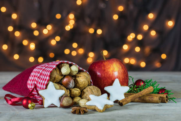 Christmas bag filled with nuts, cookies, apple and spices Christmas decoration with nuts, biscuits, apple and spices. walnut cookies stock pictures, royalty-free photos & images
