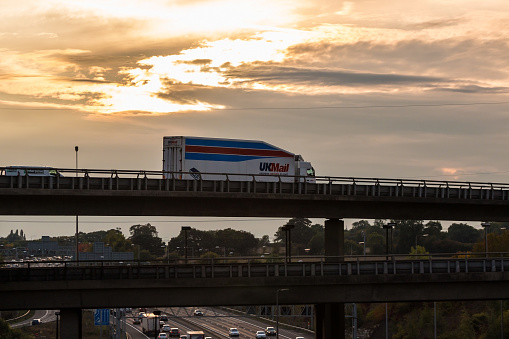 London: Uk Mail lorry on the viaduct over British motorway M25 during sunset