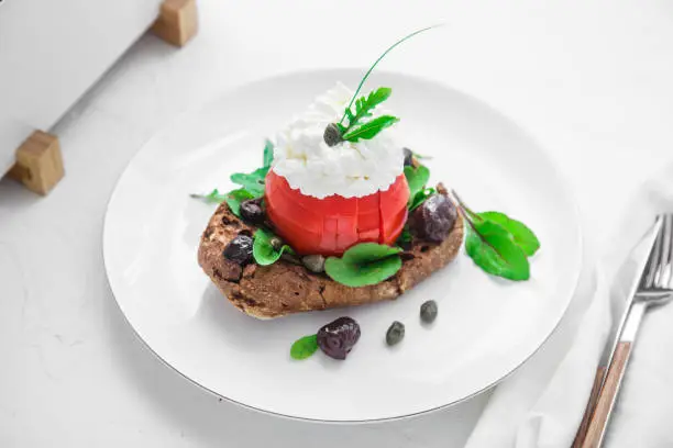 Dakos barley rusk with mizitra cheese, tomato, olives, oregano and olive oil. Greek appetizer