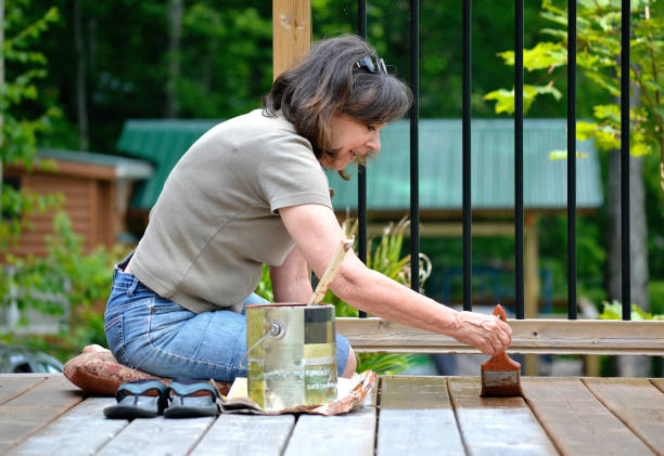 Lifestyle, Senior woman, 50+, paints a deck. stock photo