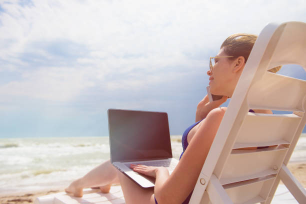 istock Woman with laptop on the beach 854700744