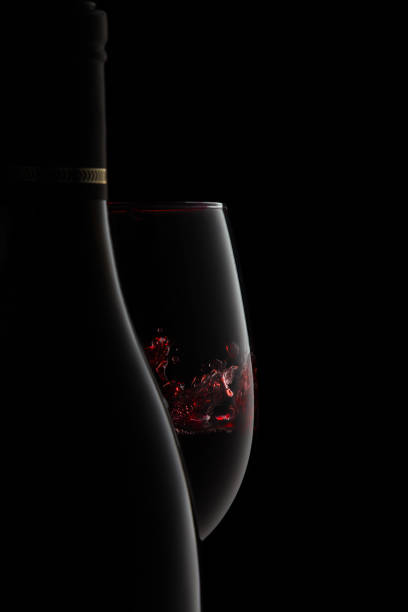 uma garrafa e um copo de vinho tinto elegante com esguicho. - wine wine bottle bottle red - fotografias e filmes do acervo