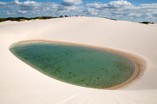 Oval and deep lake in the Maranhão sheets, with some people in the background Maranhão, Brazil.