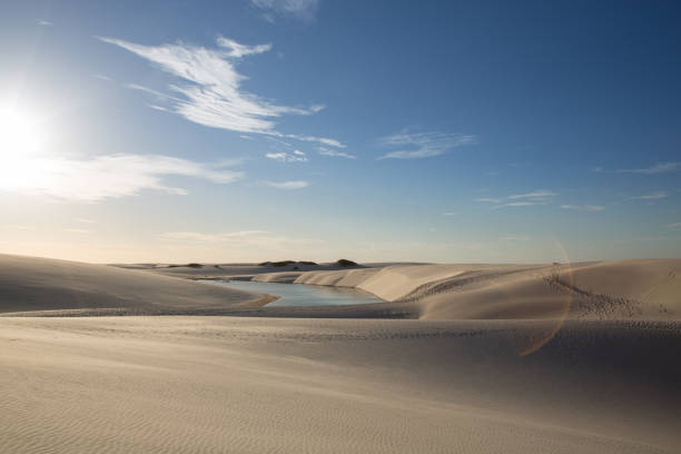 Golden dunes at the sunset of the lençois maranhenses with a photo flare Golden dunes at the sunset of the lençois maranhenses with a photo flare. Maranhão, Brazil. brazil desert maranhao state national park stock pictures, royalty-free photos & images