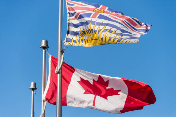 istock Canada and British Columbia flags waving over blue sky in Vancouver, BC, Canada 854733640