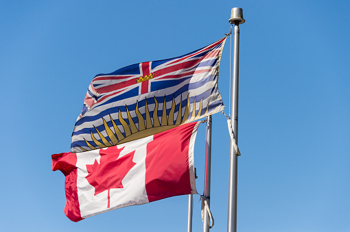 British Columbia flag waving over blue sky in Vancouver, BC, Canada