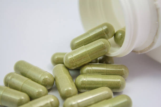 istock herbal capsules spilling out of a bottle 854758278