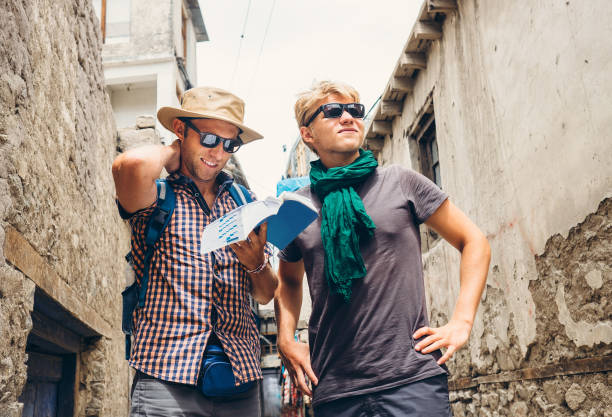 Two tourists try to navigate with guidebook on unknown asian street