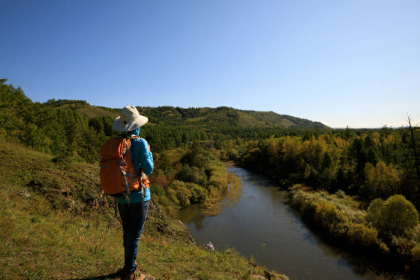 istock woman hiking with backpack at the riverside mountain 854787136