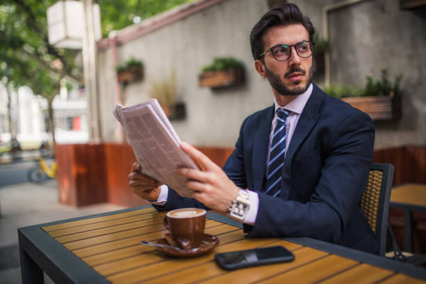istock Man reading newspaper in cafe 854791402
