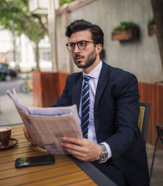 istock Businessman reading newspaper on a coffee break 854795844