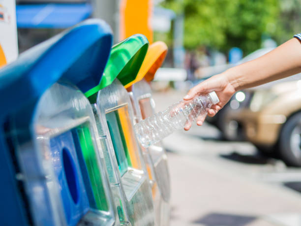 istock Closeup portrait woman hand throwing empty plastic water bottle in recycling bin. 854796378
