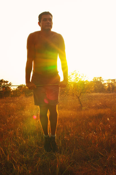 istock Man walking on slackline in the meadow at sunset. 854797172