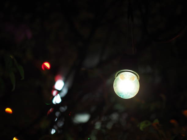 istock Pale blue light bulb hanging in the dark, small bokeh background 854804682