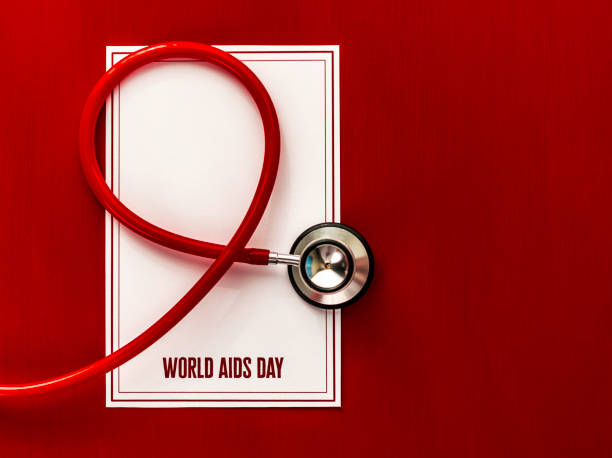 recordatorio de día del sida del mundo con estetoscopio sobre fondo rojo - aids awareness ribbon fotos fotografías e imágenes de stock