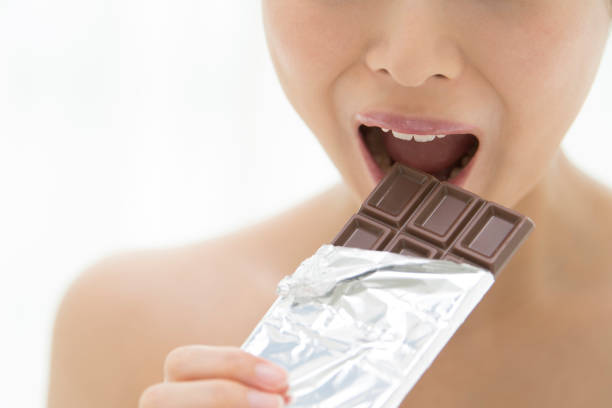 istock A woman eating it by gnawing chocolate boards. 854885462