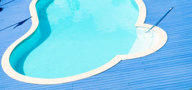 istock Swimming pool with blue deck and broom 854888642
