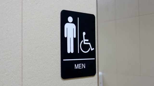 Motion of man and disable washroom logo on wall