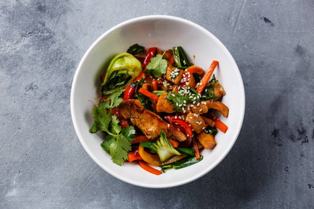 Chicken meat with vegetable in bowl stir fry on wok Chicken meat with vegetable in bowl stir fry on wok on concrete background stir fried stock pictures, royalty-free photos & images