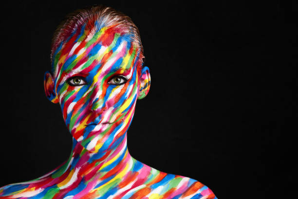 Fashion portrait of a man with ultraviolet paint on his body and neon light in cyberpunk style.