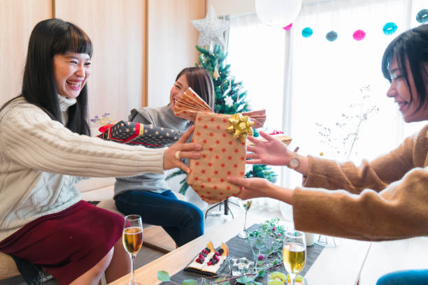 istock Young female friends exchanging Christmas presents 854924024