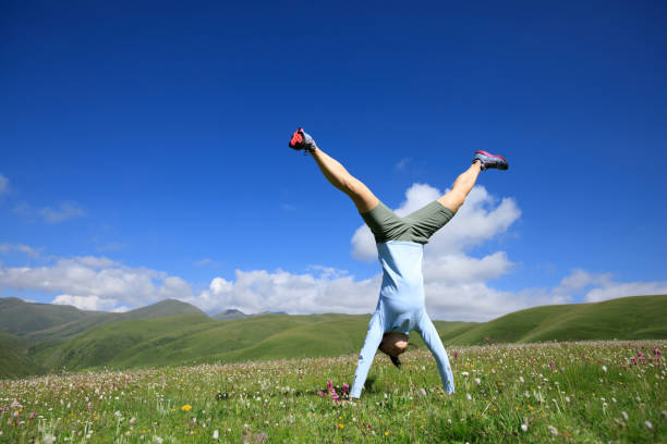 istock handstand woman have fun in a mountain peak meadow 854930810