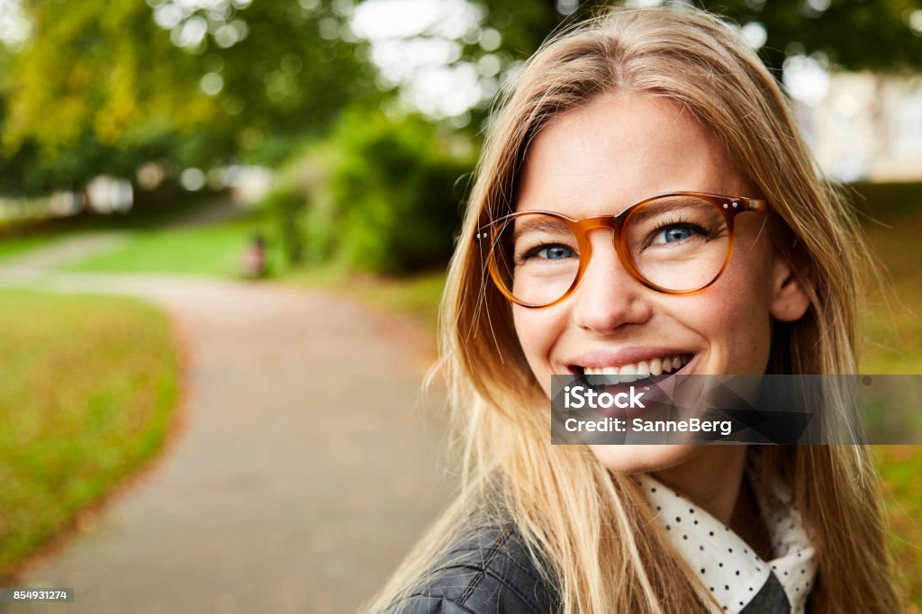 Occhiali sorridenti ragazza nel parco - Foto stock royalty-free di Occhiali da vista