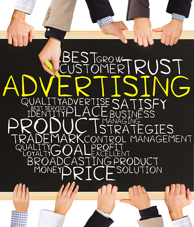 Photo of business hands holding blackboard and writing ADVERTISING concept