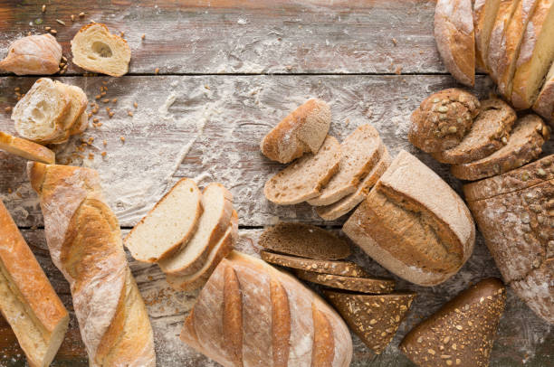 istock Bread bakery background. Brown and white wheat grain loaves comp 854953590